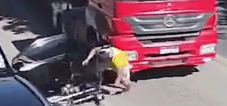 TRÂNSITO: Motorista abre porta e joga motociclista para debaixo de caminhão.